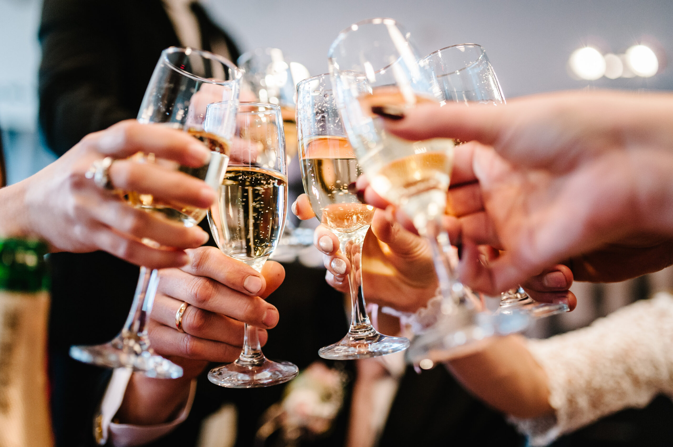 Group of people toasting with champagne flutes at a celebration.